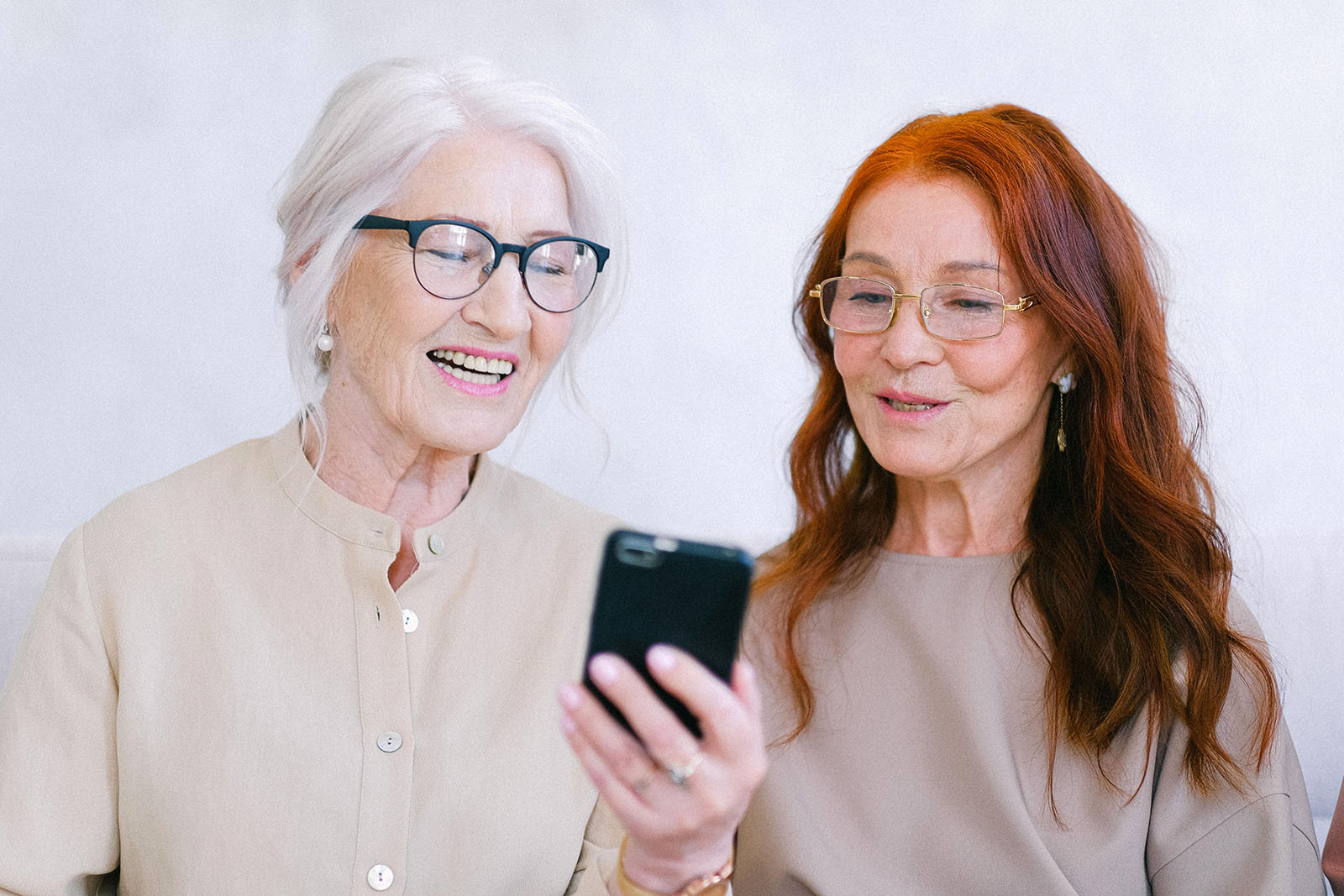 Women smiling while looking at cell phone