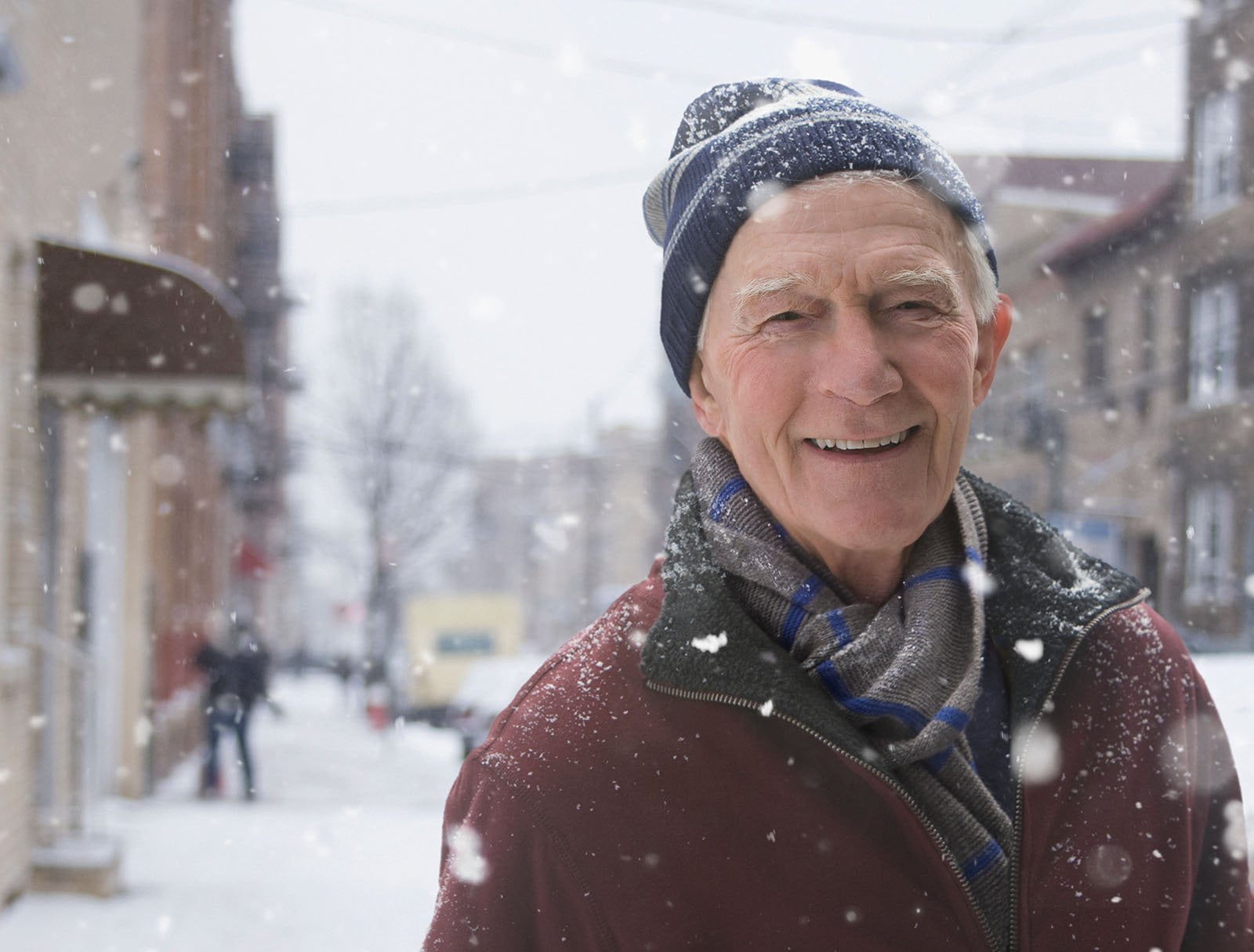 Elderly man smiling outside in the snow