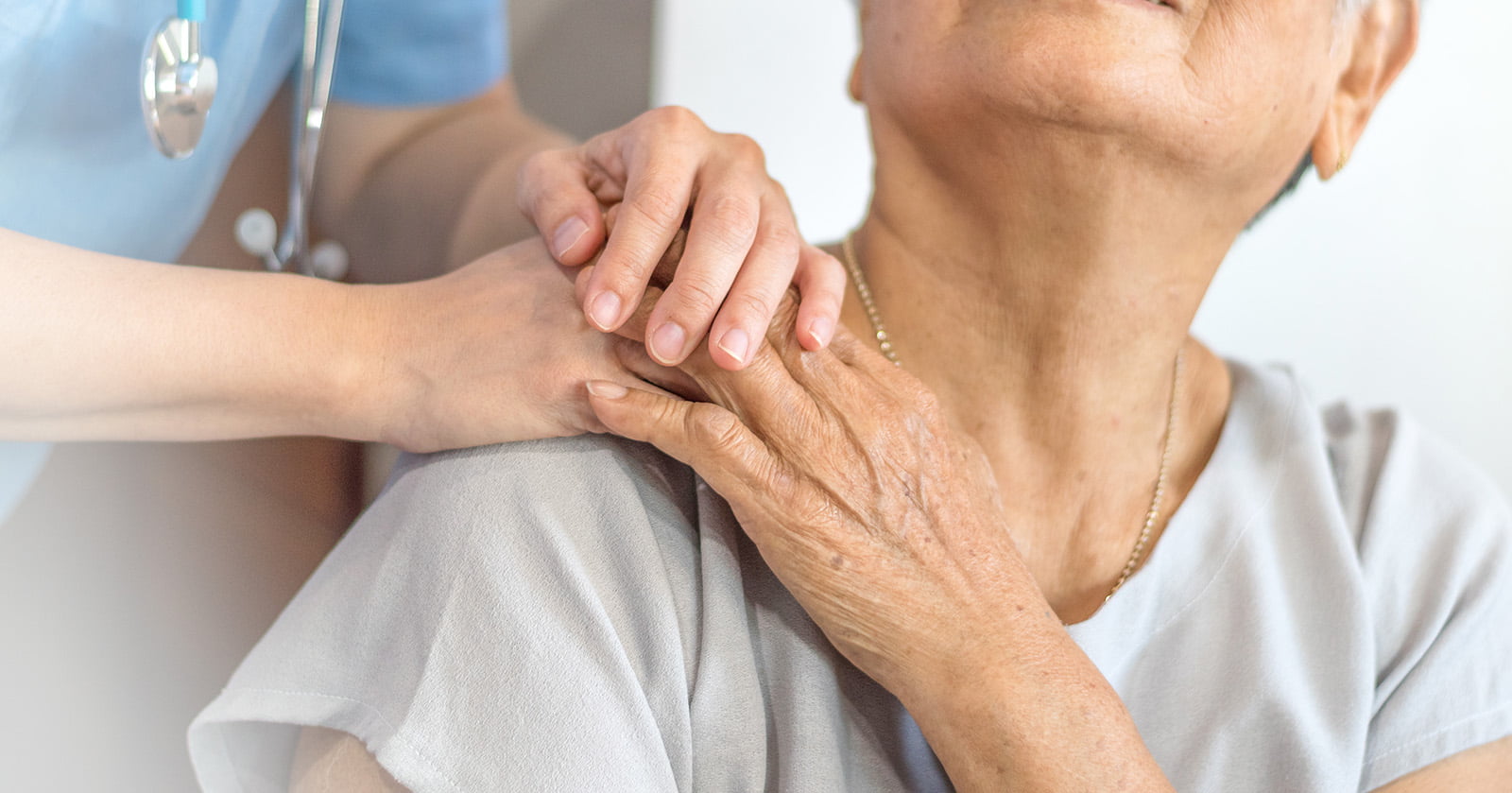 Caregiver comforting elderly person